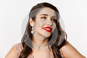 Concept of New Year celebration and winter holidays. Headshot of glamour woman with earrings and red lips, dressed for