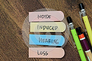 Concept of Noise Induced Hearing Loss write on sticky notes isolated on Wooden Table