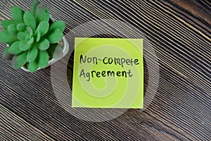 Concept of Non-Compete Agreement write on sticky notes isolated on Wooden Table