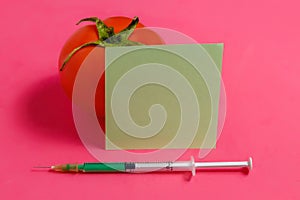 Concept of Non-natural Products, Gmo. Syringe, Sticker and Red Tomato on Pink Background,