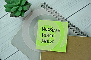 Concept of Nursing Home Abuse write on sticky notes isolated on Wooden Table