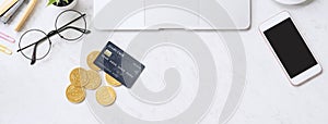 Concept of online payment with credit card with smart phone, laptop computer on office desk on clean bright marble table