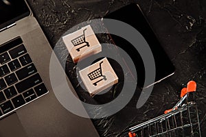 Concept of online Shopping. Boxes, laptop and smartphone on a grey table