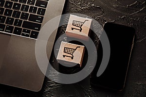 Concept of online Shopping. Boxes and smartphone on a grey table