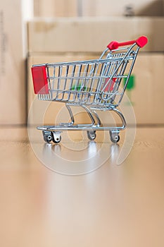 Concept of online shopping: Little shopping cart on delivery boxes