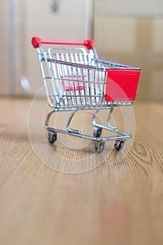 Concept of online shopping: Little shopping cart on delivery boxes