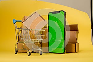 Concept online Sopping. boxes and shopping bag on Trolley with Smartphone Online Shopping screen