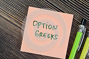 Concept of Option Greeks write on sticky notes isolated on Wooden Table