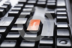 The concept of the orange button on the computer that is design to enter a searching key font on a black PC keyboard for office