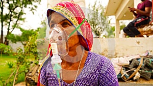 Old woman admitted in hospital and inhaling emergency oxygen with canula mask photo
