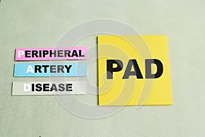 Concept of PAD - Peripheral Artery Disease write on sticky notes isolated on Wooden Table