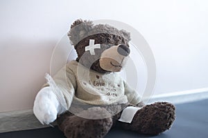 a concept of pain and illness problem, teddy bear toy wrapped in bandage, accident injury