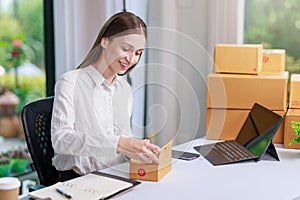 Concept of parcel delivery and selling online,Retailer Using a calculator to calculate sales for the day on an online store for