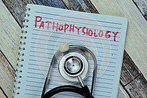 Concept of Pathophysiology write on book with stethoscope isolated on Wooden Table