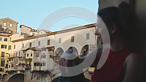 Concept of peace, calmness and beauty. Adorable asian woman having rest on the Vecchio bridge in Florence . Beautiful