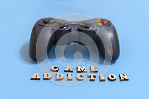 The concept of people's game addiction on computer games. dzhostik and the inscription game addiction on a blue background.