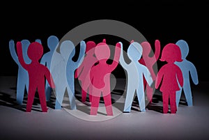 Concept of people strike and protest. Paper multi-colored little men with raised hands, on a dark background. Freedom and