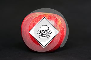 Concept of pesticide residues in agricultural food products dangerous to humans, showing a red apple with poison symbol