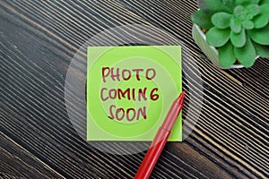 Concept of Photo Coming Soon write on sticky notes isolated on Wooden Table