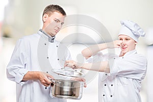 Concept photo - cooks and foul soup in a pan, shooting on the background