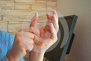 Concept photo of pain or spasm in thumb. Man hold thumb with palm of the other hand, which muscles of which are spasming or aching