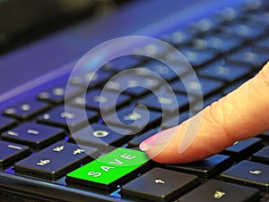 Finger pressing green save saving button on keyboard computer buying internet online web trading trade