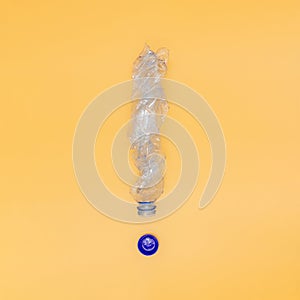 The concept of plastic pollution of nature, a plastic bottle in the shape of an exclamation mark on a yellow background