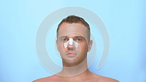 Concept of plastic surgery, a man after a plastic surgery on the face, rhinoplasty, with a bandage on the nose. on blue