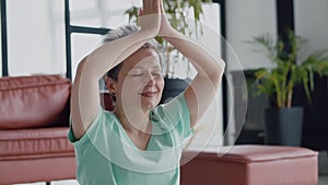 Concept of a pleasant and useful pastime in old age. Old woman make yoga exercise at home. Mature woman have meditation