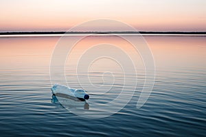 Concept of pollution, creative background. A plastic bottle floating in the ocean, non-decomposable plastic, pollution of the photo