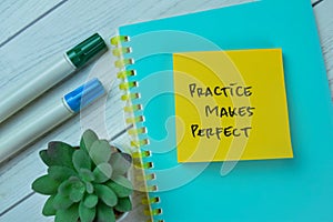 Concept of Practice Makes Perfect write on sticky notes isolated on Wooden Table