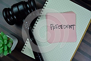 Concept of Precedent write on sticky notes with gavel isolated on Wooden Table