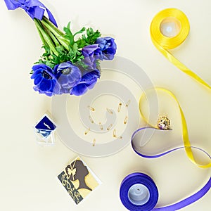 Concept of preparation for the holiday or wedding. Blue flowers, ring and heard made of ribbons on light background. Top view, fl