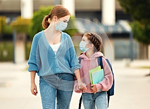 Concept of preventing a coronavirus covid-19 and viral infections. Mother and child daughter    in a medical mask to school
