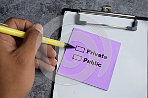 Concept of Private or Public write on sticky notes  on Wooden Table