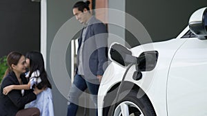 Concept of progressive family with home charging station for electric vehicle.