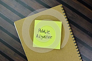 Concept of Public Adjuster write on sticky notes isolated on Wooden Table