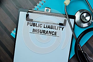 Concept of Public Liability Insurance write on paperwork isolated on Wooden Table