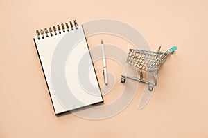 Concept for purchases Shopping list. Shopping cart and nonebook for your text