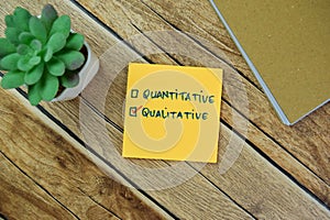 Concept of Quantitative and Qualitative write on sticky notes isolated on Wooden Table