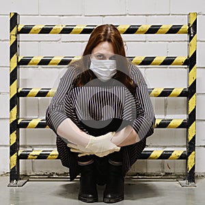 Concept of quarantine and protection from the flu virus. A protective yellow-black barrier and redhead woman