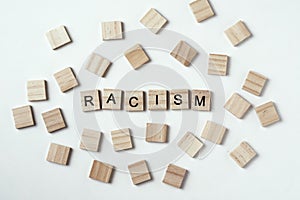 Concept of racism and misunderstanding between people, prejudice and discrimination. Wooden block with word racism on the white