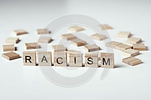 Concept of racism and misunderstanding between people, prejudice and discrimination. Wooden block with word racism on the white