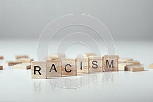 Concept of racism and misunderstanding between people, prejudice and discrimination. Wooden block with word racism on the white