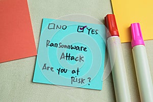 Concept of Ransomware Attack, Are You at Risk? write on sticky notes isolated on Wooden Table