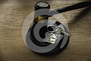 Concept of real estate auction, legal system and property division after divorce. Gavel and house key on a wooden background