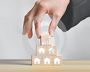 Concept of real estate sales growth with icon on wooden cube stack,loan investment residential building house, real estate, proper