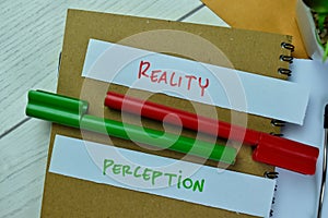 Concept of Reality or Perception write on sticky notes isolated on Wooden Table