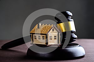 Concept of realty and law. Little wooden house and judges gavel