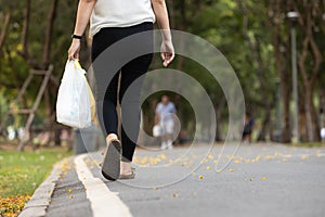 Concept of recycling,reduce the amount of waste,asian woman carrying a plastic bag used in a previous shopping session for reuse,